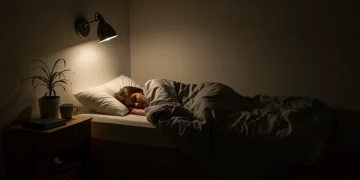 Pessoa dormindo tranquilamente em um quarto sereno com iluminação suave, simbolizando a melhora da qualidade do sono.